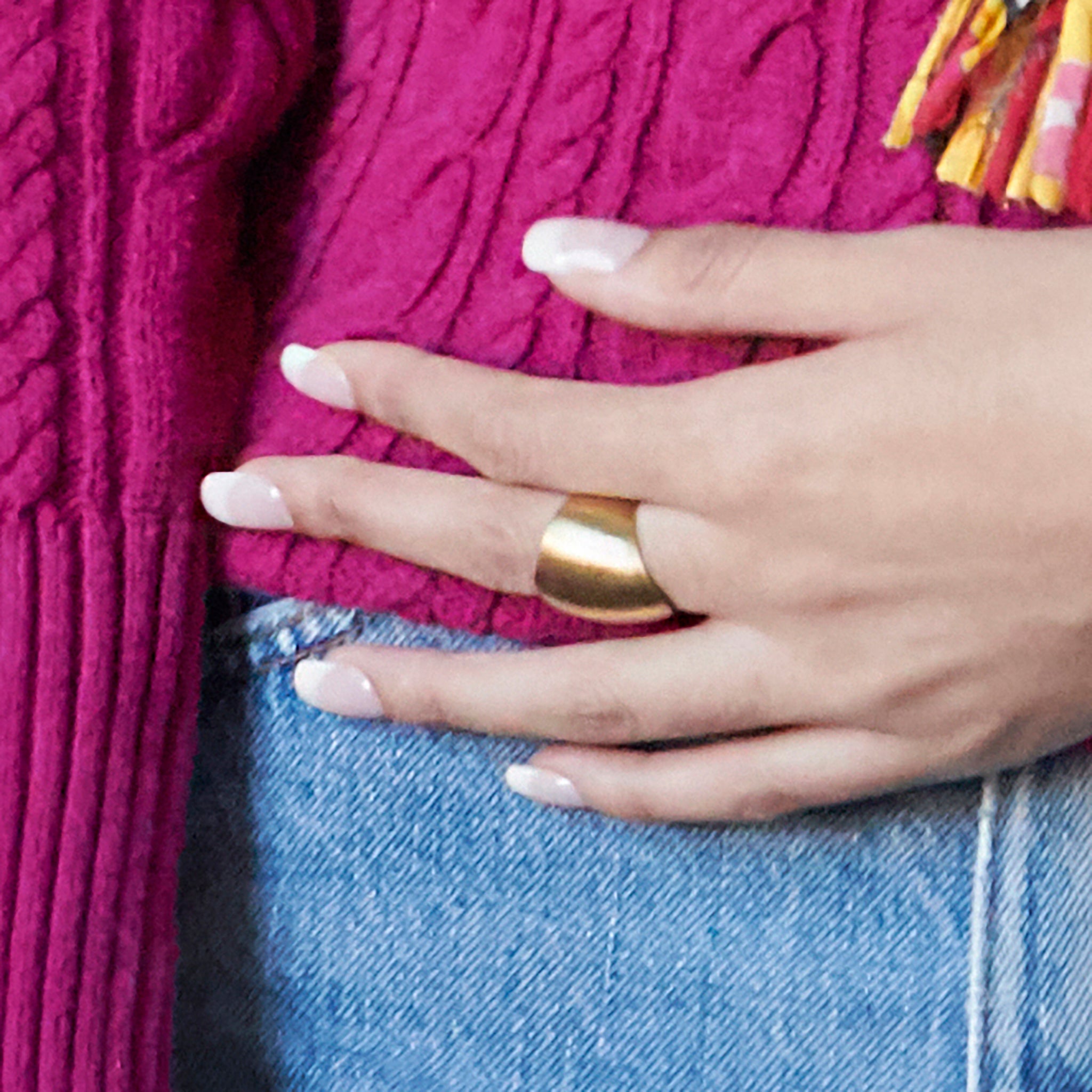 A woman's hand is shown with a single gold ring.