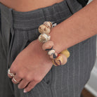 Model wearing the Kantha Desertscape Coterie Bracelet that is made of unique, super large oval-shaped Kantha beads alternate with smaller-sized ovals to create this incredible statement style.