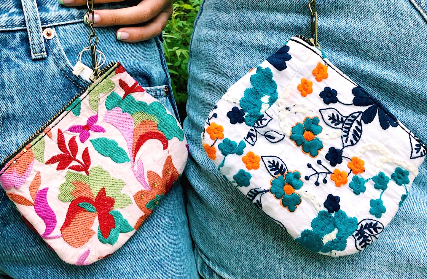 Two woman hold Kutch Zipper Pouches by their hips.