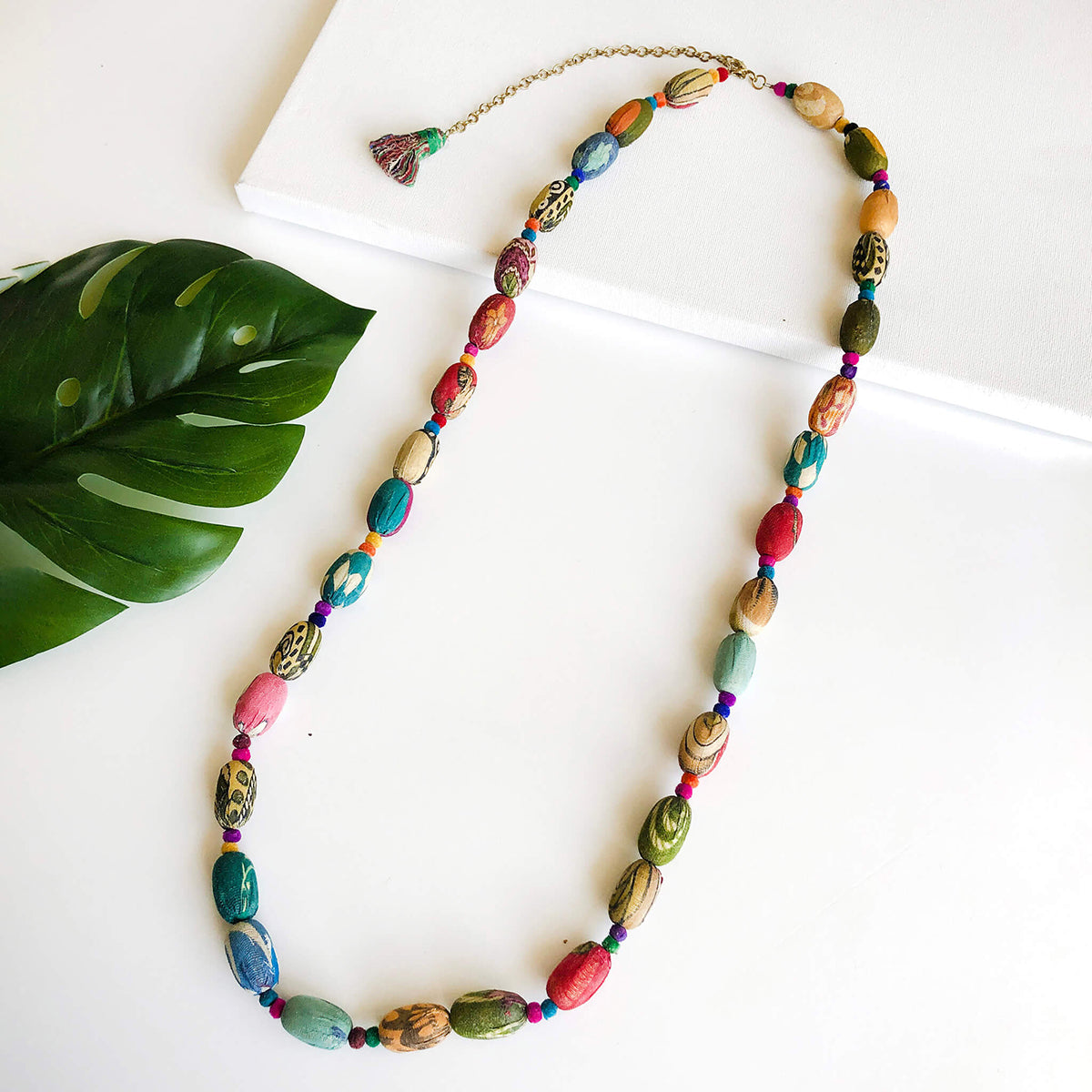 A multicolored, beaded necklace against a white background.