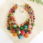 A mulitcolored, beaded necklace on a tan background.