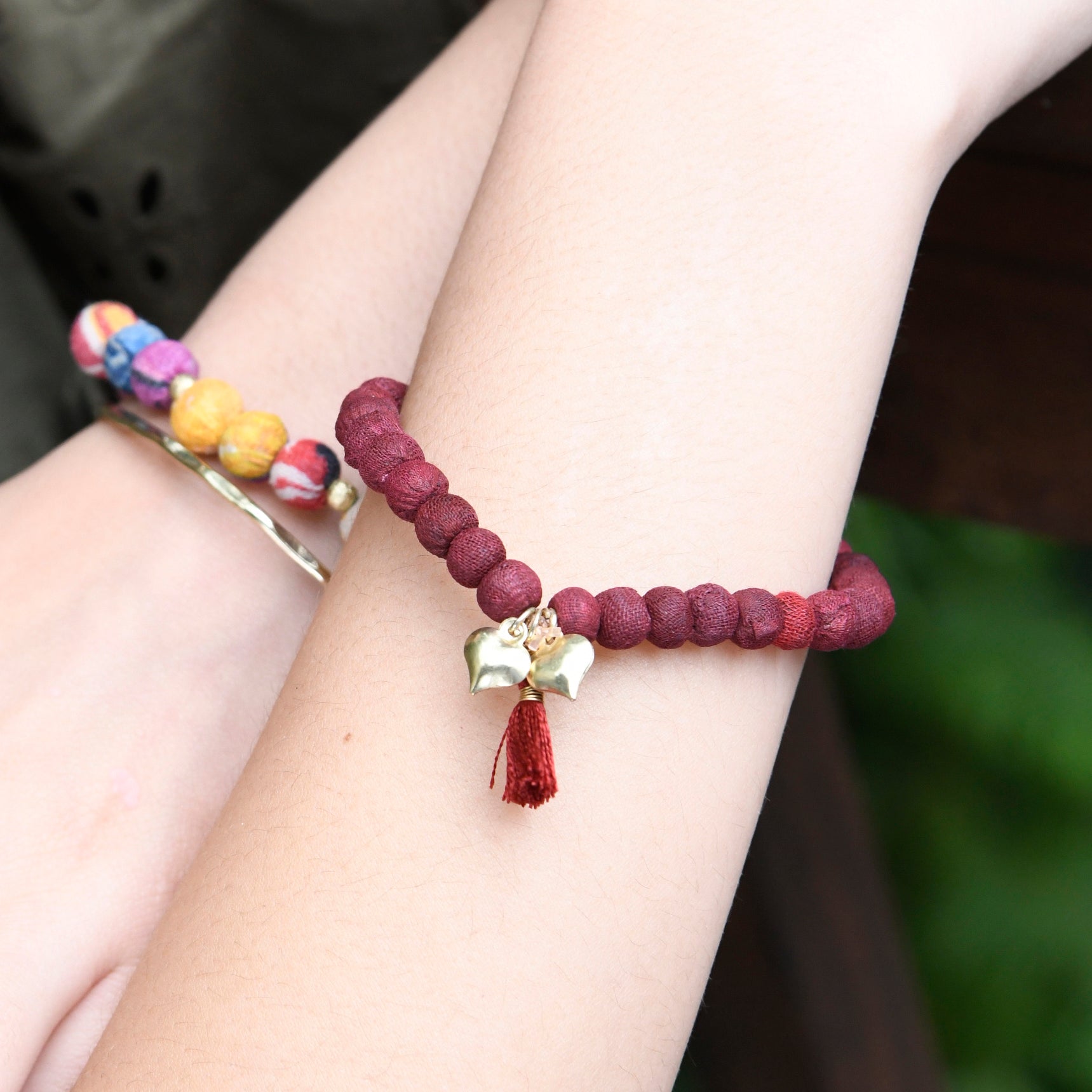 A close up of a woman's wrist and the red beaded bracelet she wears.