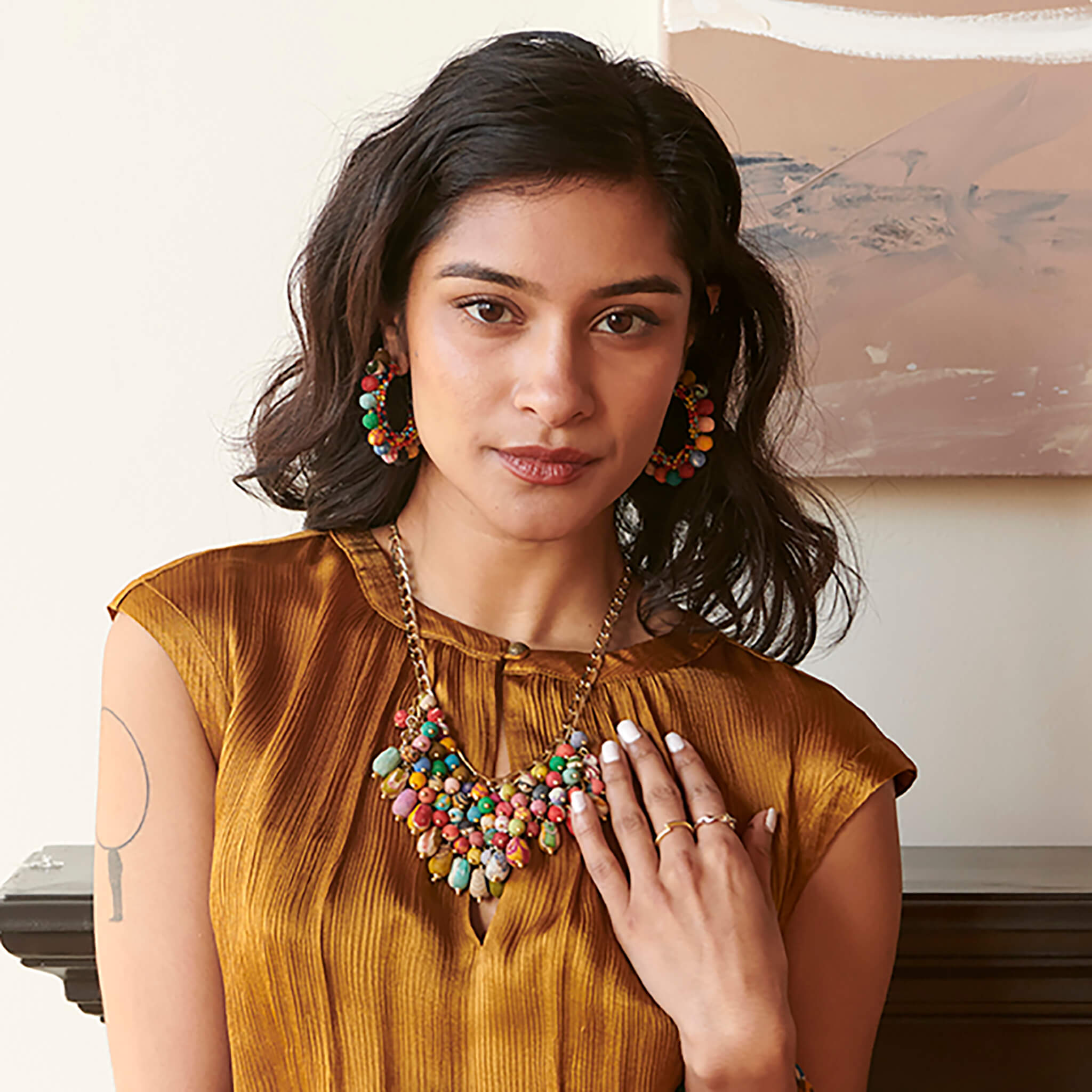 A woman wears the Confetti Kantha Hoops and statement necklace..