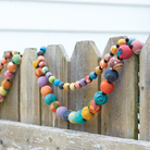 The Large & Small Kantha Garlands hang on a fence.