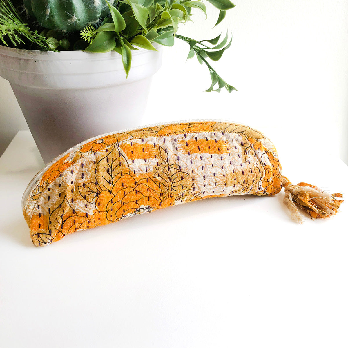 An orange patterned Kantha Brush Bag.