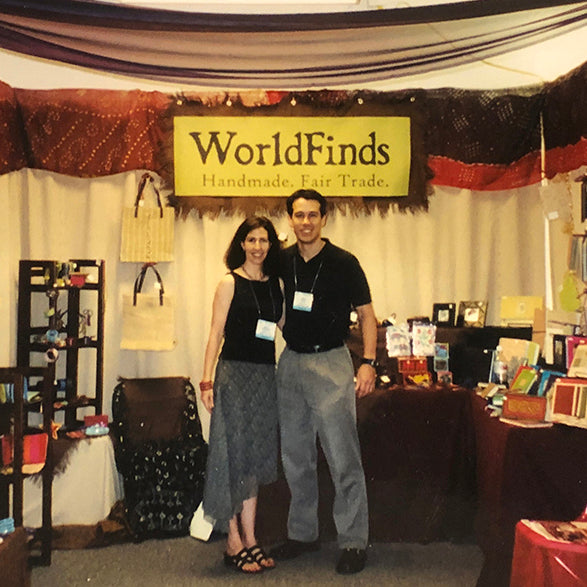A man & woman stand in front of a tradeshow booth