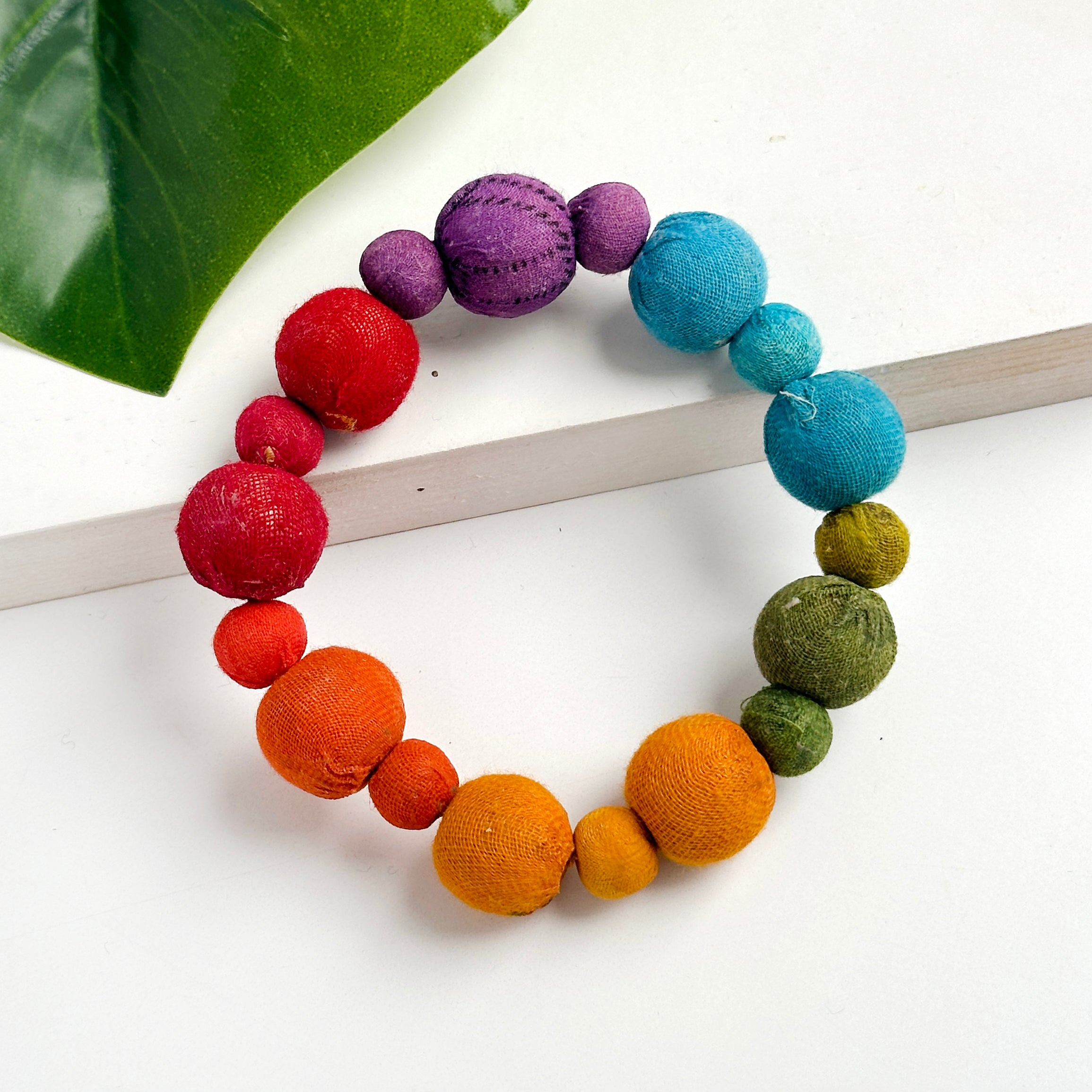 Kantha Prism Poetic Bracelet made of beads that have been sorted and arranged into vibrant, color-blocked sections for an multichromatic rainbow-like display of color.
