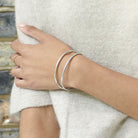 A model wears the Double Arch Cuff in Silver.