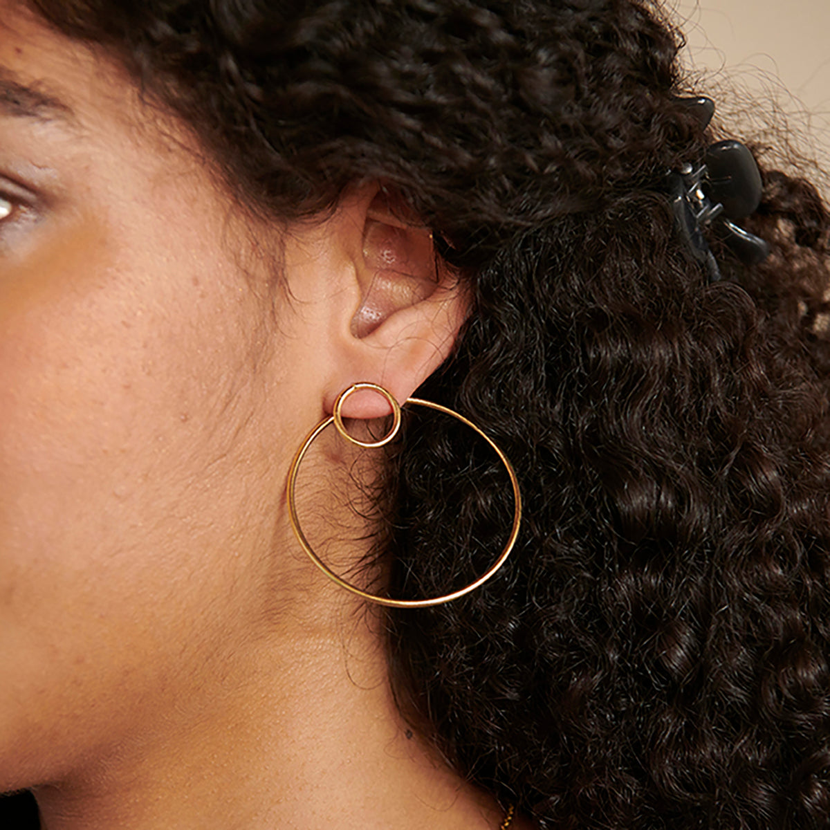 A model wears the Double Hoop Posts in Gold.