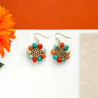 Kantha beads surround a circle of matte gold seed beads in a playful flower shape to form the Kantha Capri Sunflower Earrings. 