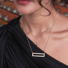 A model wears the Dangling Bar Pendant Necklace.
