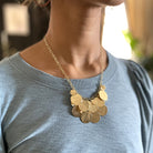 A woman's necklace is shown, adorned with a gold charm necklace.