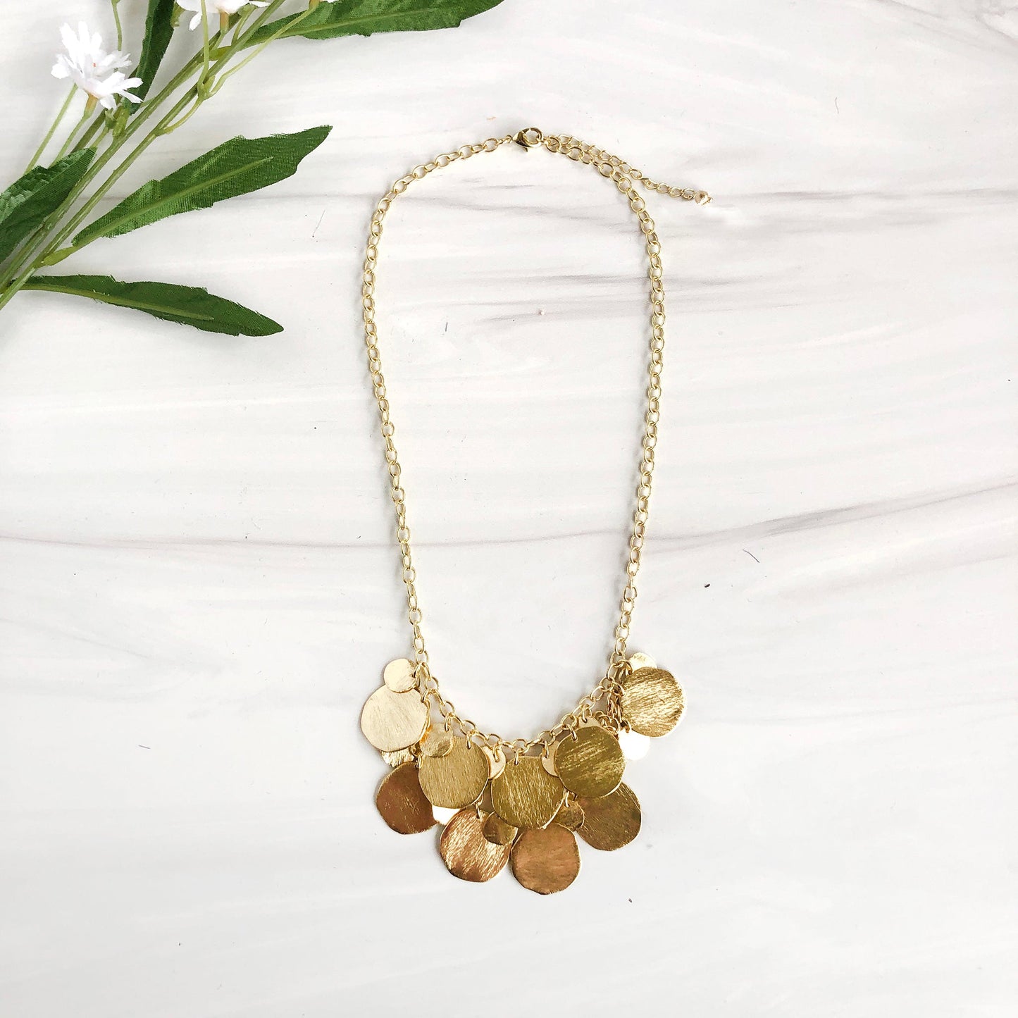 Load image into Gallery viewer, Layers of large and small handcrafted gold metal discs overlap and cascade down this glimmering pendant necklace.
