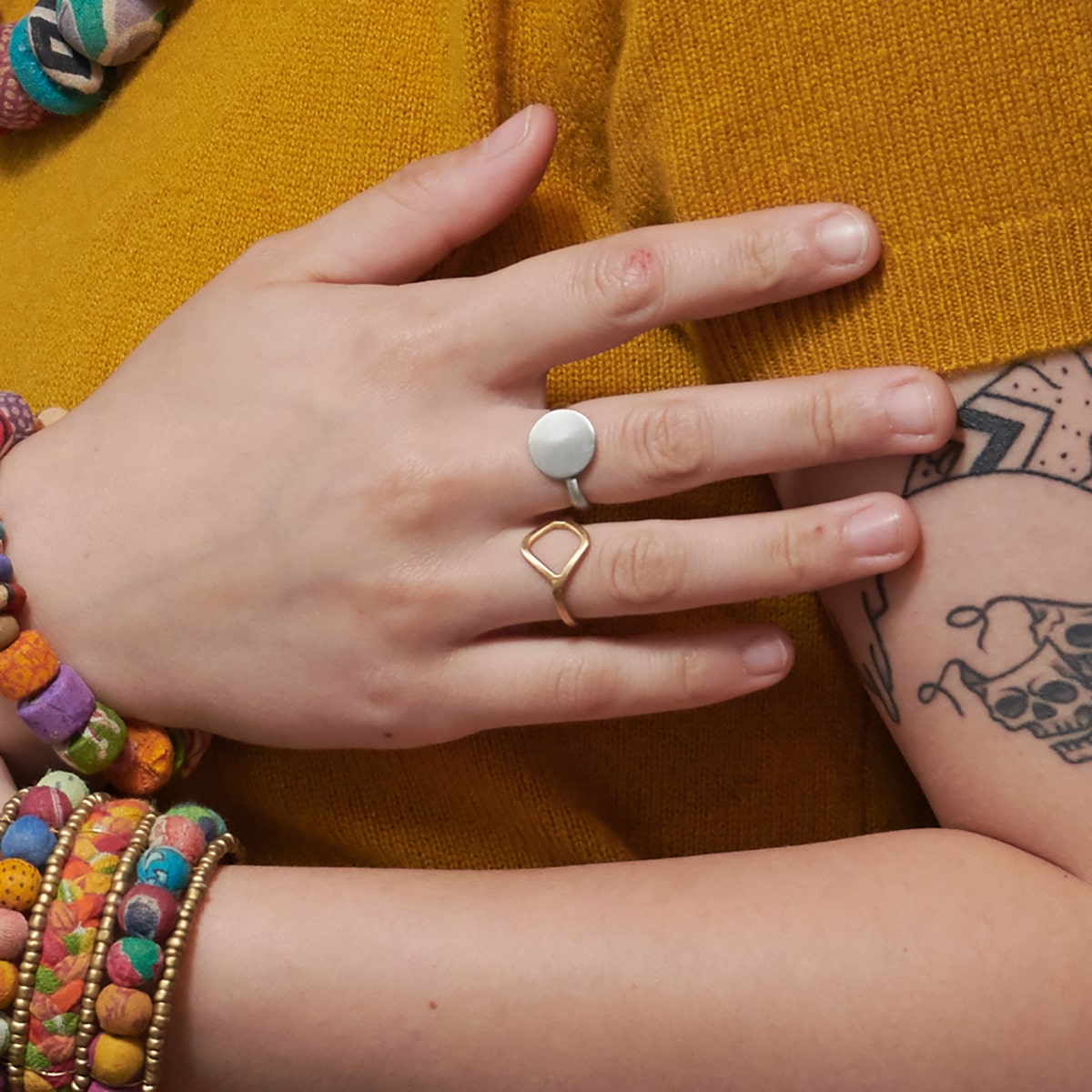 A close up of a woman's hand and the two rings on her fingers.