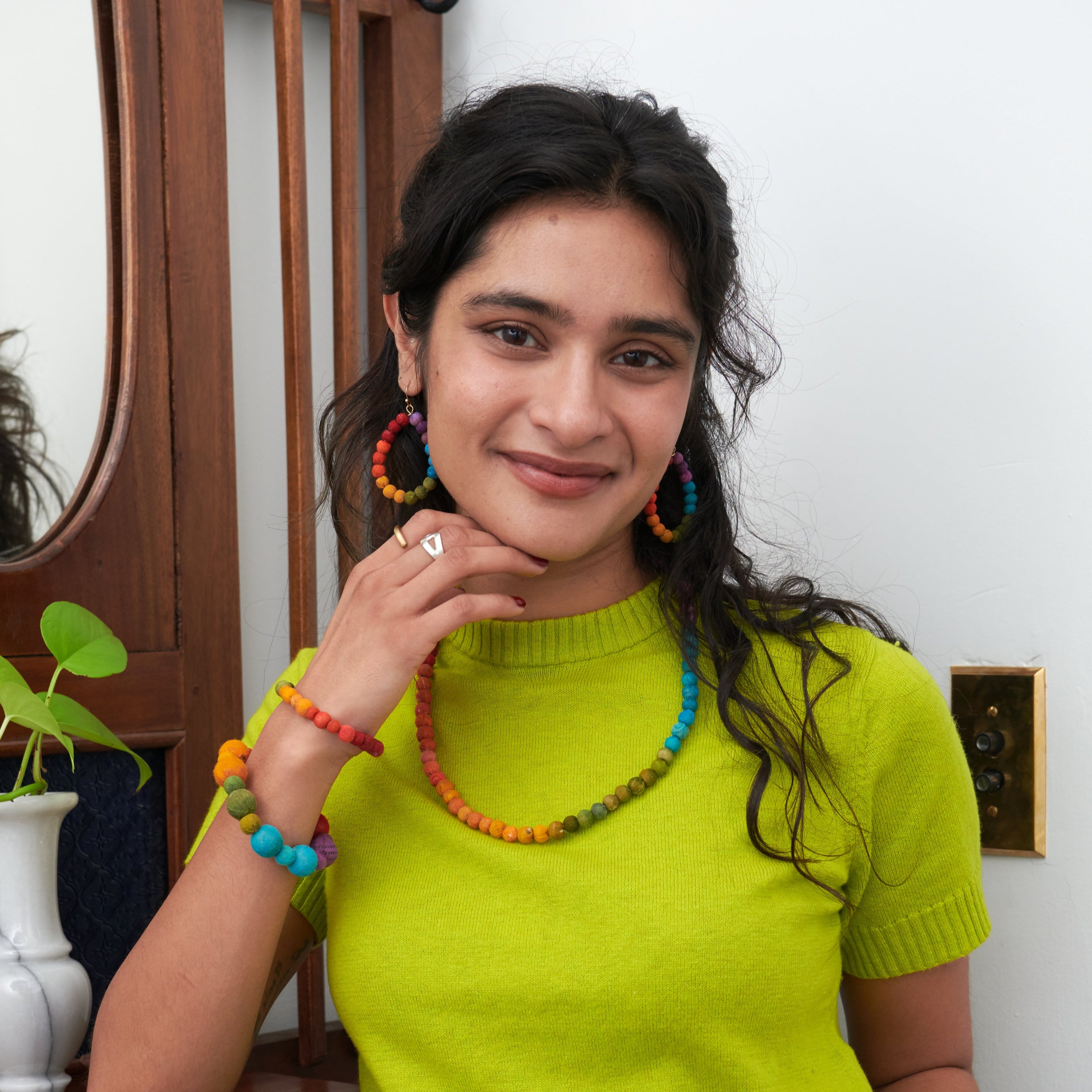 Model wearing Kantha Prism Collection made of beads that have been sorted and arranged into vibrant, color-blocked sections for an multichromatic rainbow-like display of color.

