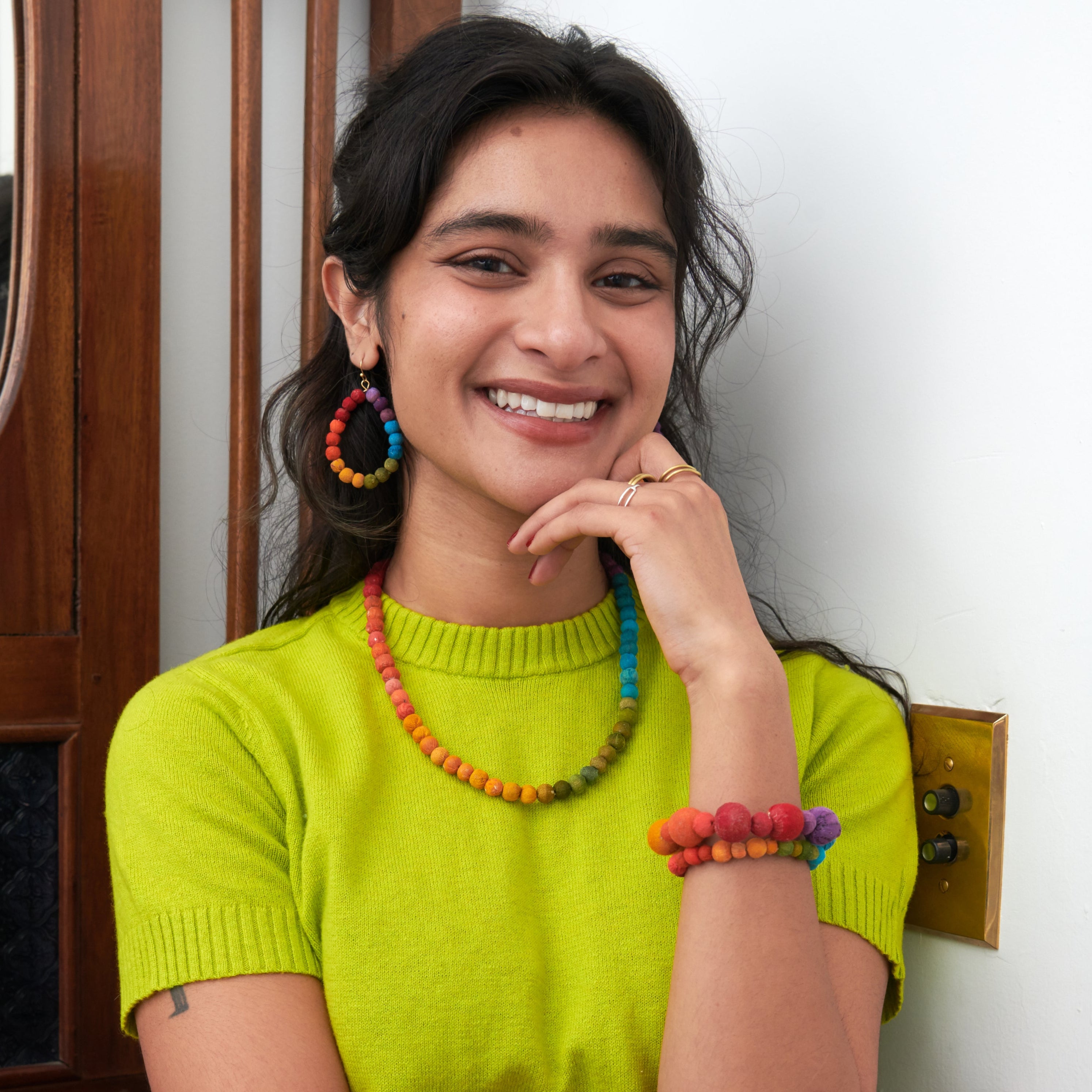 Model wearing Kantha Prism Collcetion made of beads that have been sorted and arranged into vibrant, color-blocked sections for an multichromatic rainbow-like display of color.
