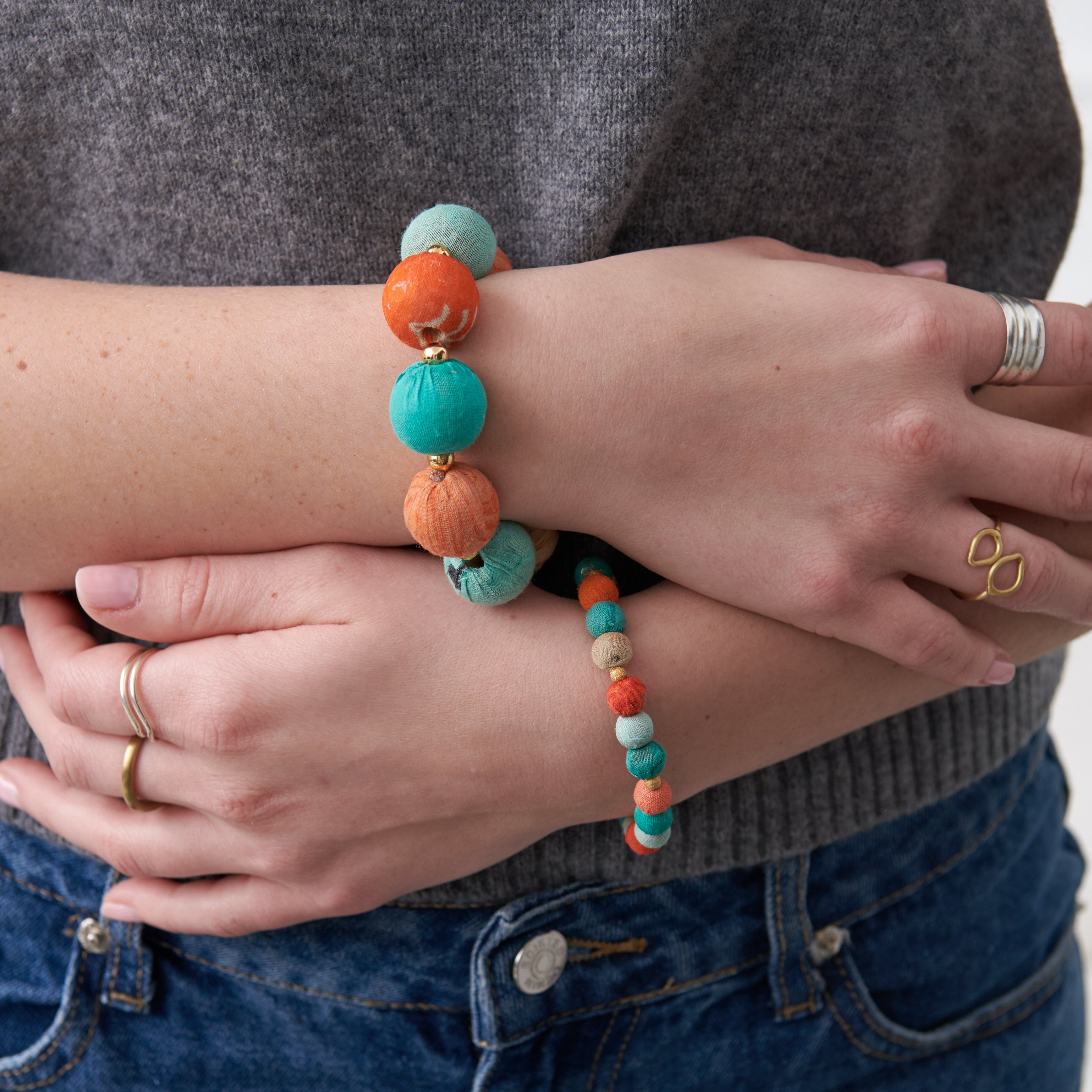 Model wearing the colorful  Kantha Capri Bracelets featuring groups of colorized Kantha beads separated by smaller metallic beads.