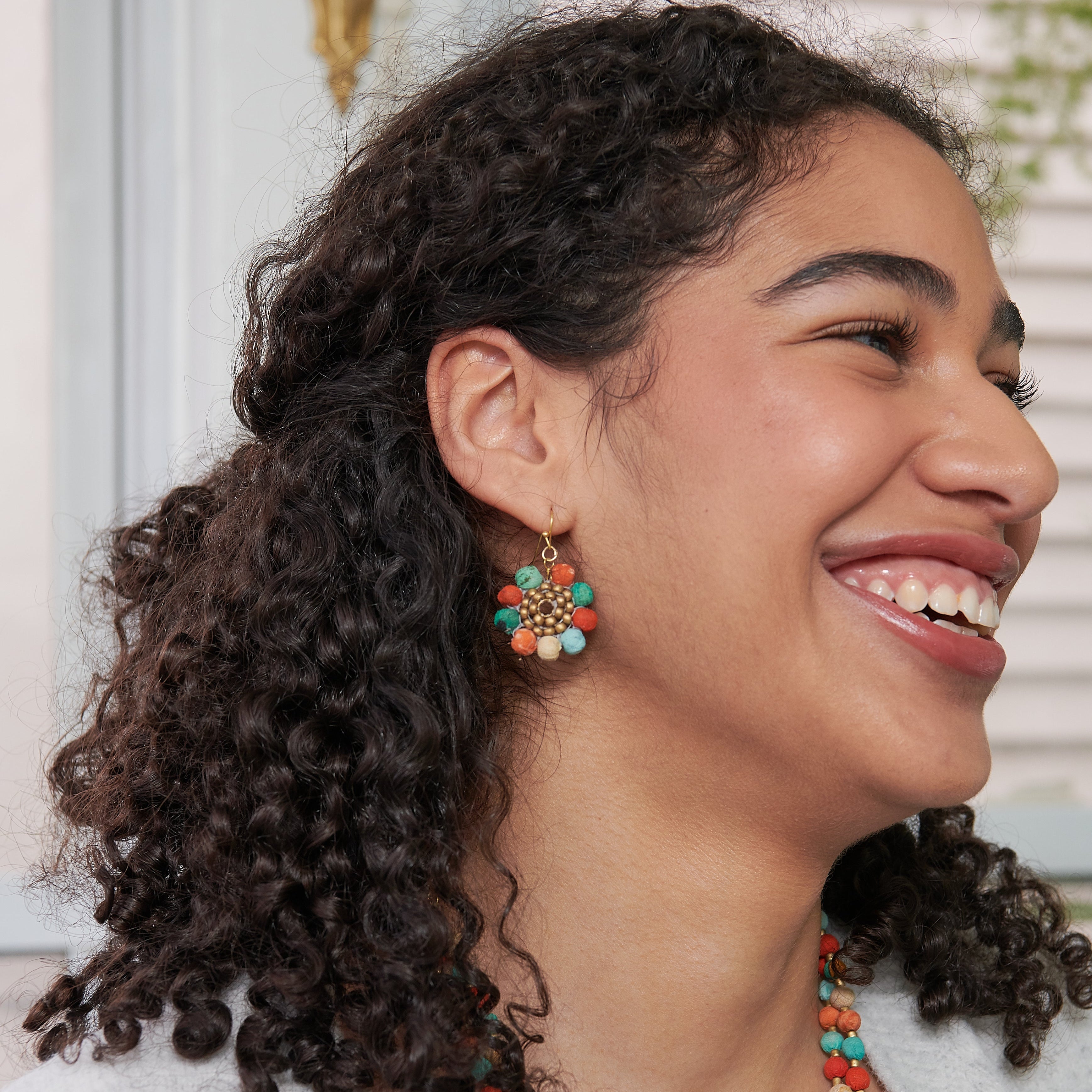 Model wearing the lightweight, colorful  Kantha Capri Sunflower Earrings. 