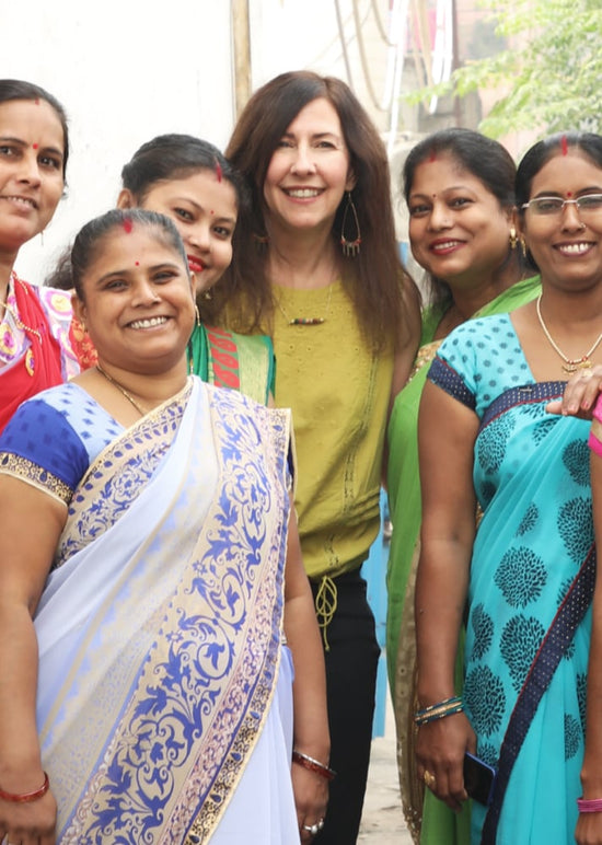 Founder Kelly Weinberger poses with a group of artisans