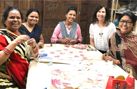 Group of female artisans making bracelets at a table