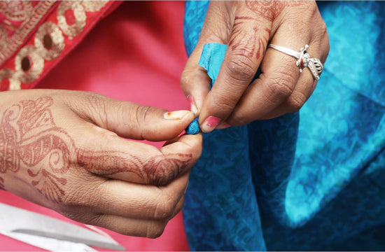 Woman's hands holding a bead and colorful fabric