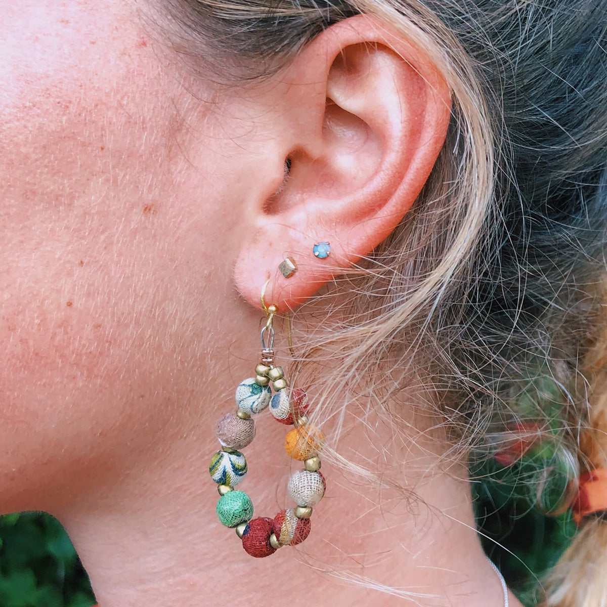 A close up of a young woman's beaded earring.