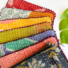 Seven quilted pouches are layered to form a rainbow of color.