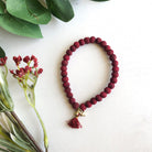 A red beaded bracelet against a white background.
