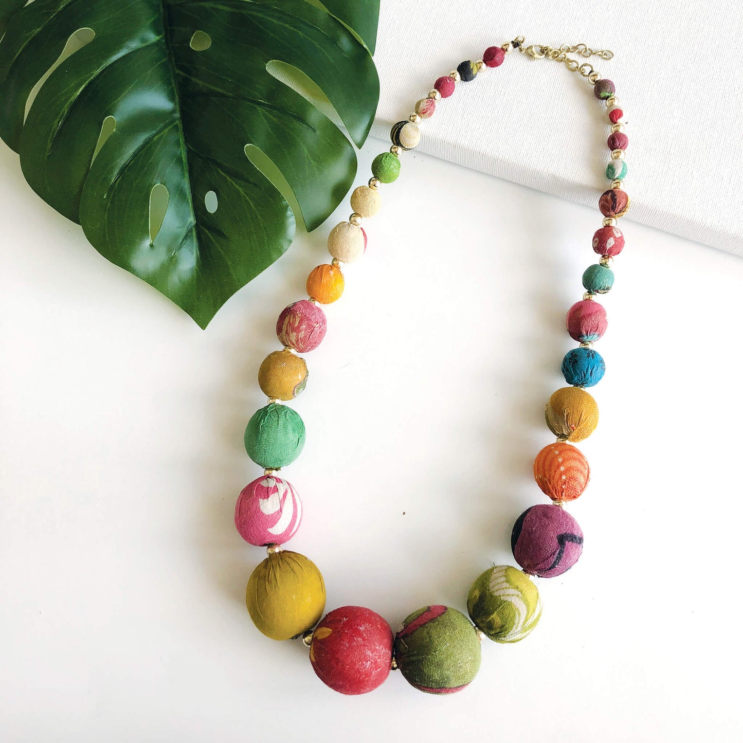 A multicolor strand of textile-wrapped beads forms this necklace.