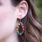 A close-up of a woman's ear and the Kantha Beaded Teardrop Earrings.