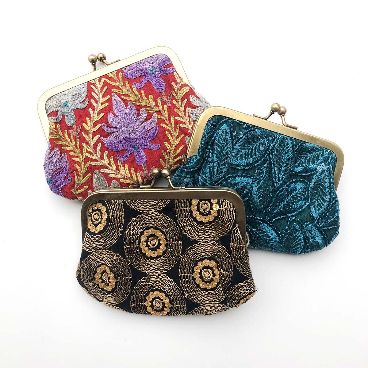 A trio of colorful patterned kisslock pouches.