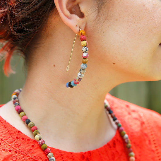 Load image into Gallery viewer, A model wears the Kantha Linear Arc Earrings.
