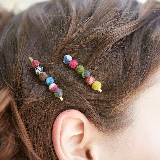 Two Sari Chic Hair Pins adorn a woman's hair.
