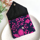 A blue and pink pouch is open to reveal a black cotton lining.