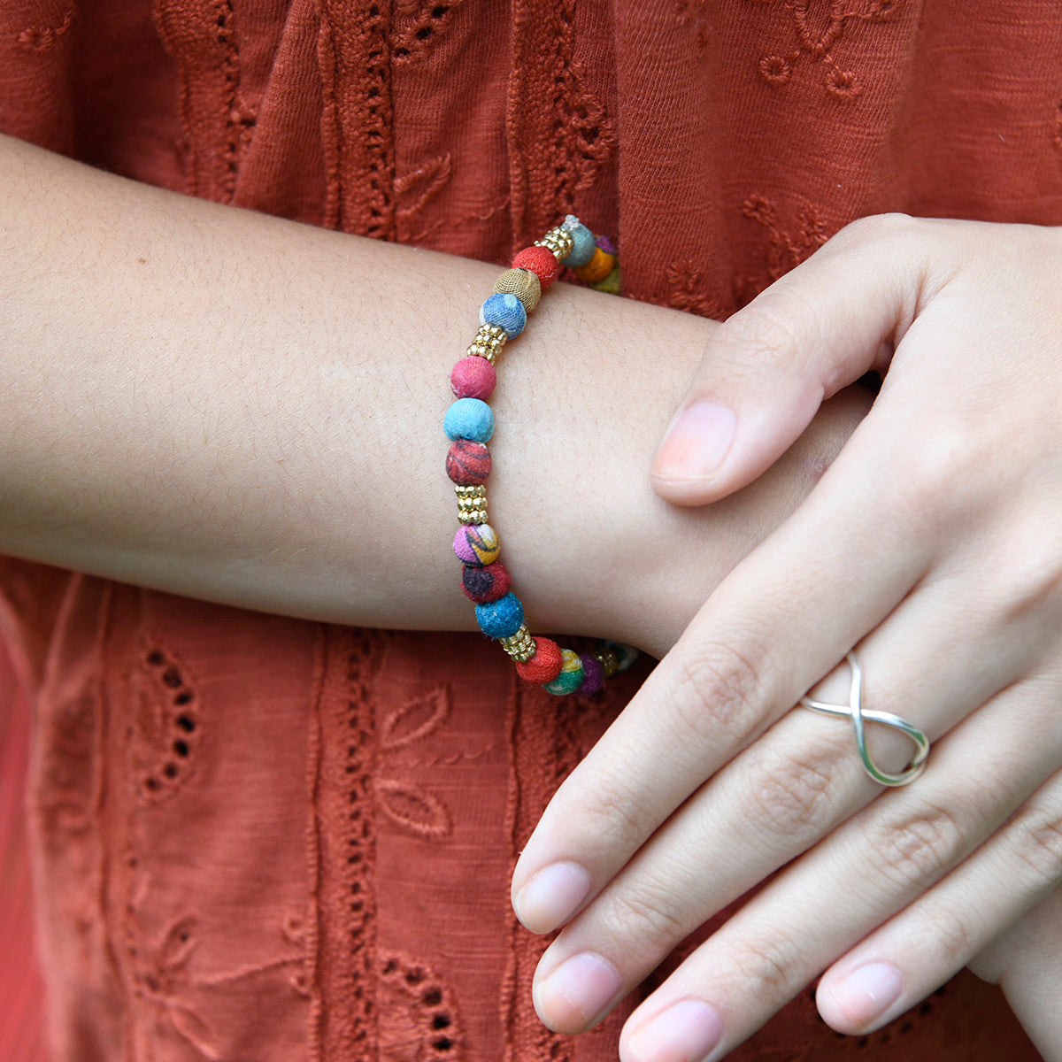 A wrist is adorned with Adorned Kantha Bracelet.