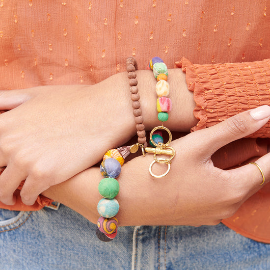 Load image into Gallery viewer, A woman wears the Kantha Shapes Toggle Bracelet with other Kantha jewelry.
