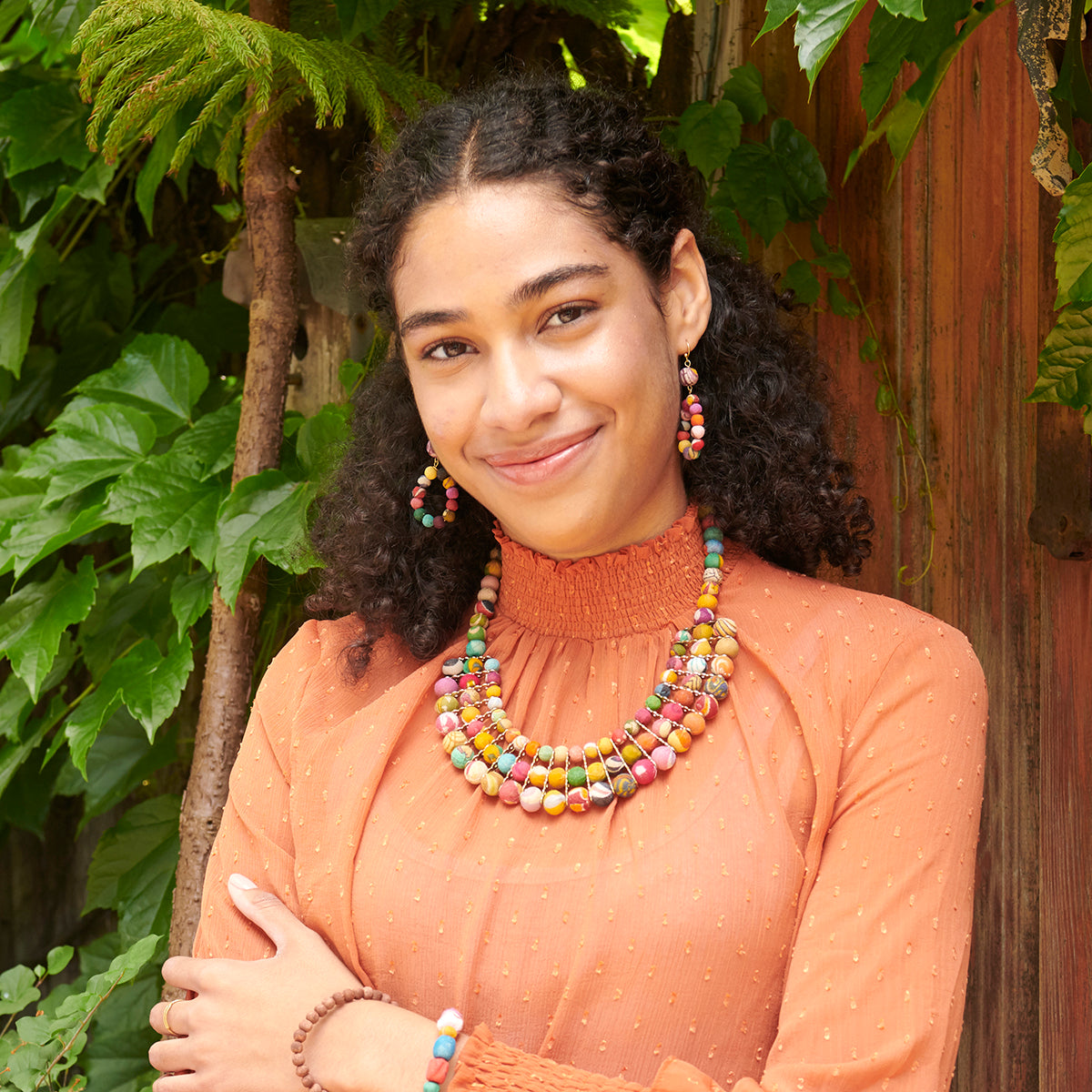 A model smiles while wearing the Kantha Gilded Collar Necklace.