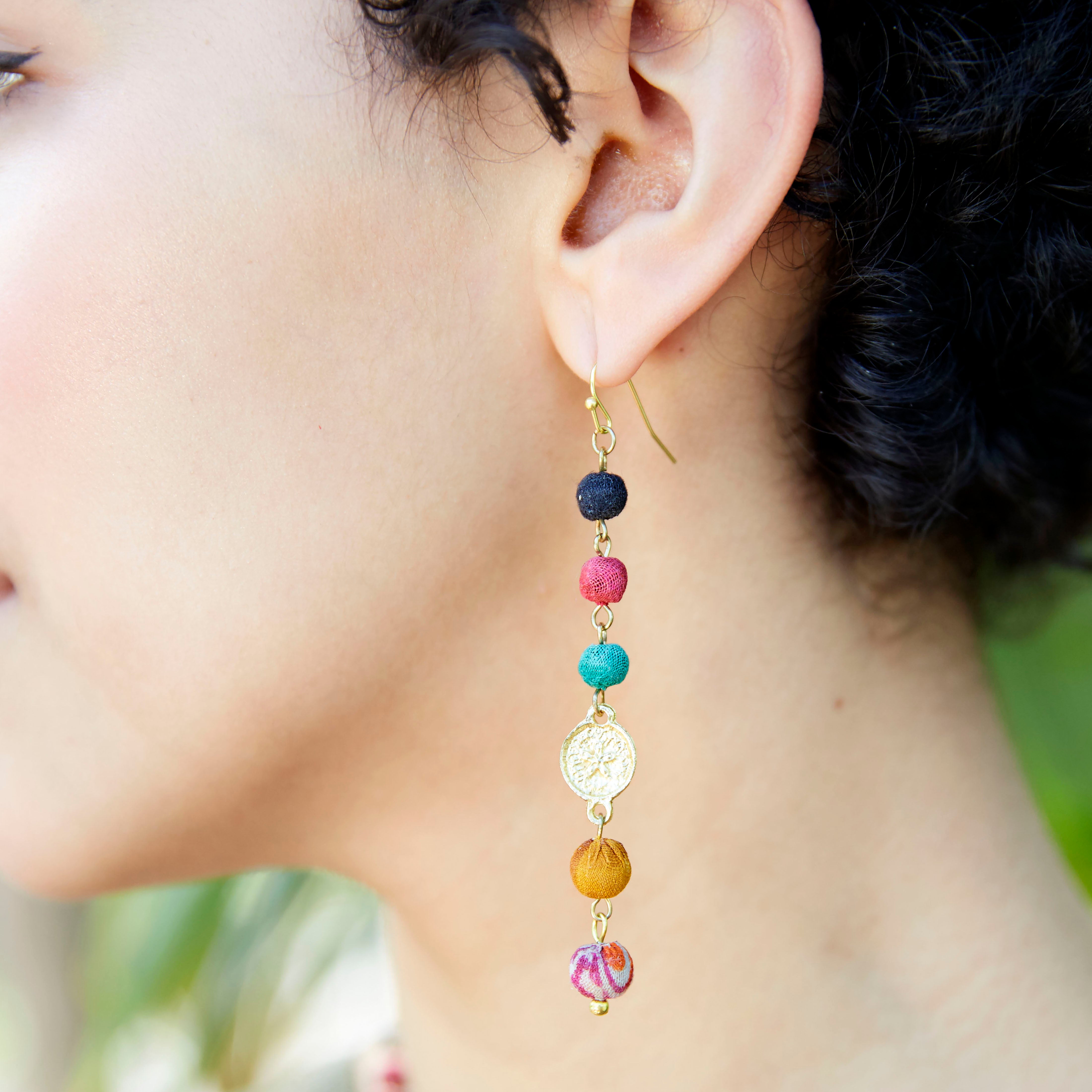 A woman wears the Kantha Raindrop Earrings.