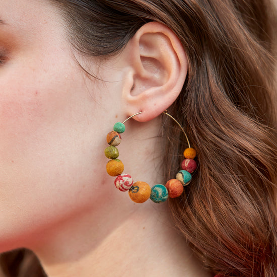 Load image into Gallery viewer, A woman wears the Kantha Graduated Hoops.
