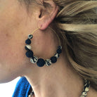 A woman wears the Kantha Indigo Graduated Hoops.