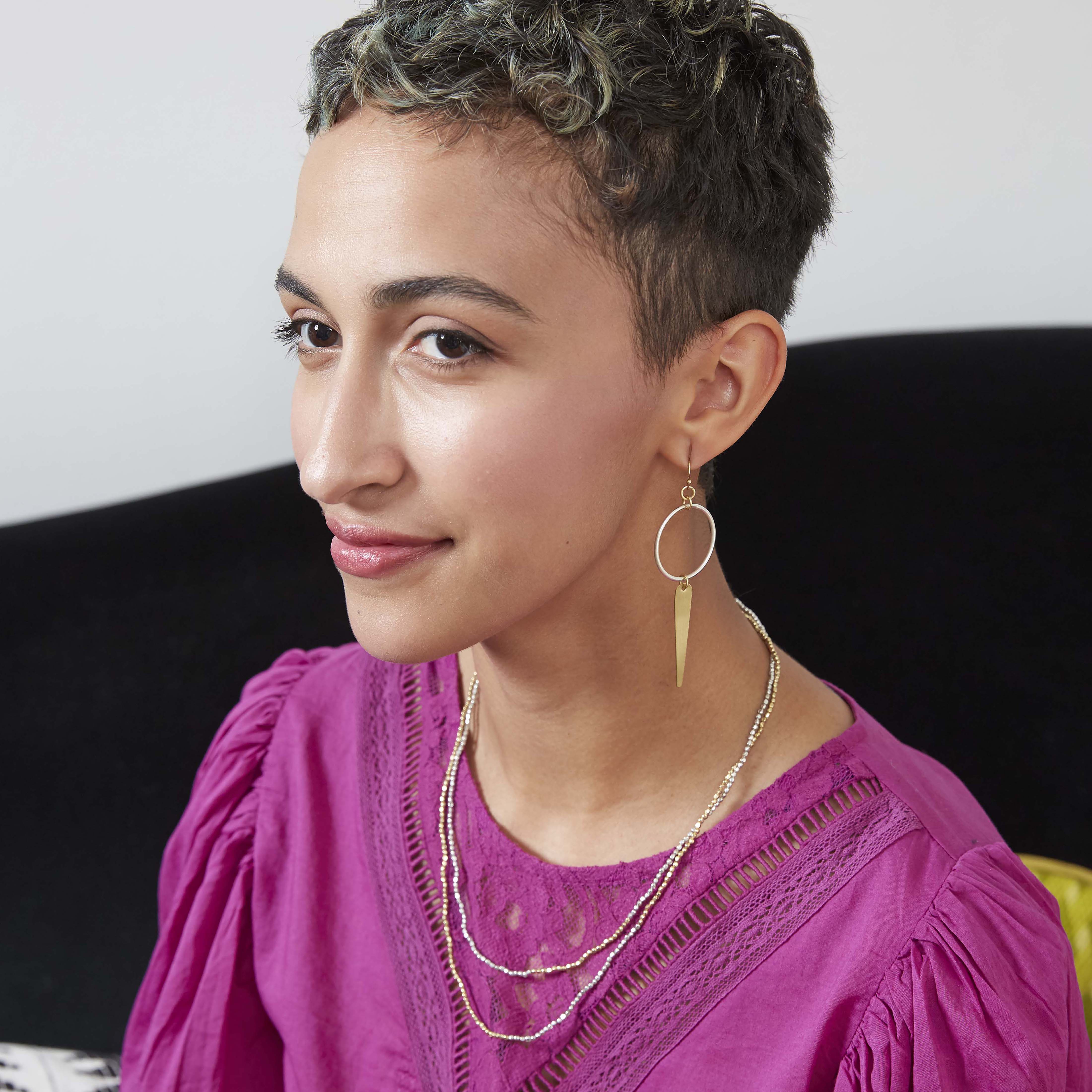 A woman models the Elongated Leaf Hoop Earrings.