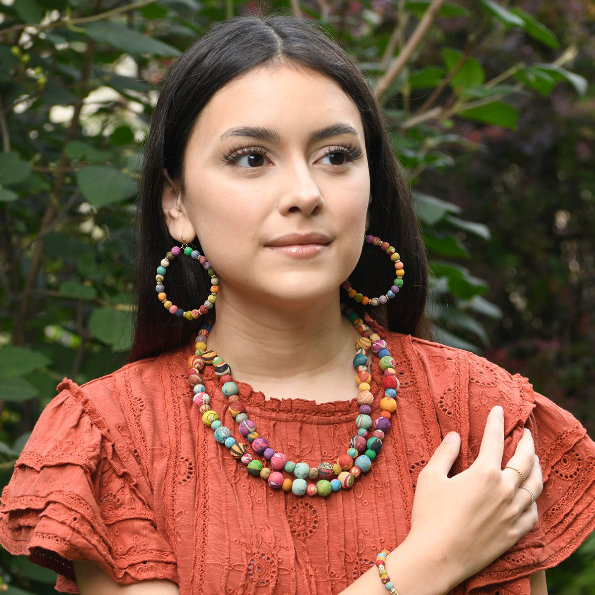 A woman models the Adorned Kantha Hoops and Tandem Necklace.