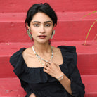 A woman models the Hera Goddess Earrings and other metallic jewelry.