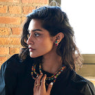 A woman models the Kantha Double Ball Posts and Kantha Portrait Necklace.