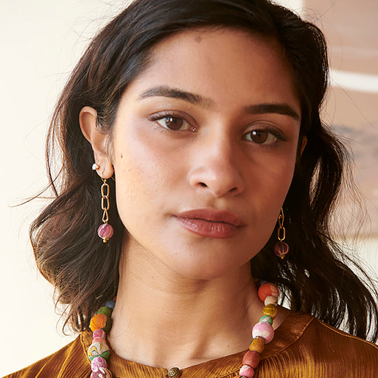 A woman models the Kantha Chain Drop Earrings.