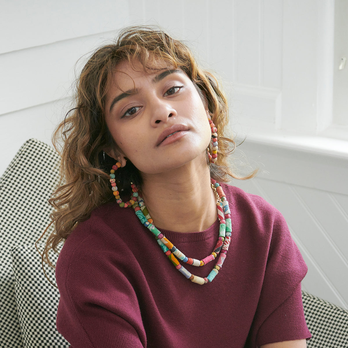 A woman wears the Kantha Rectangular Hoops.