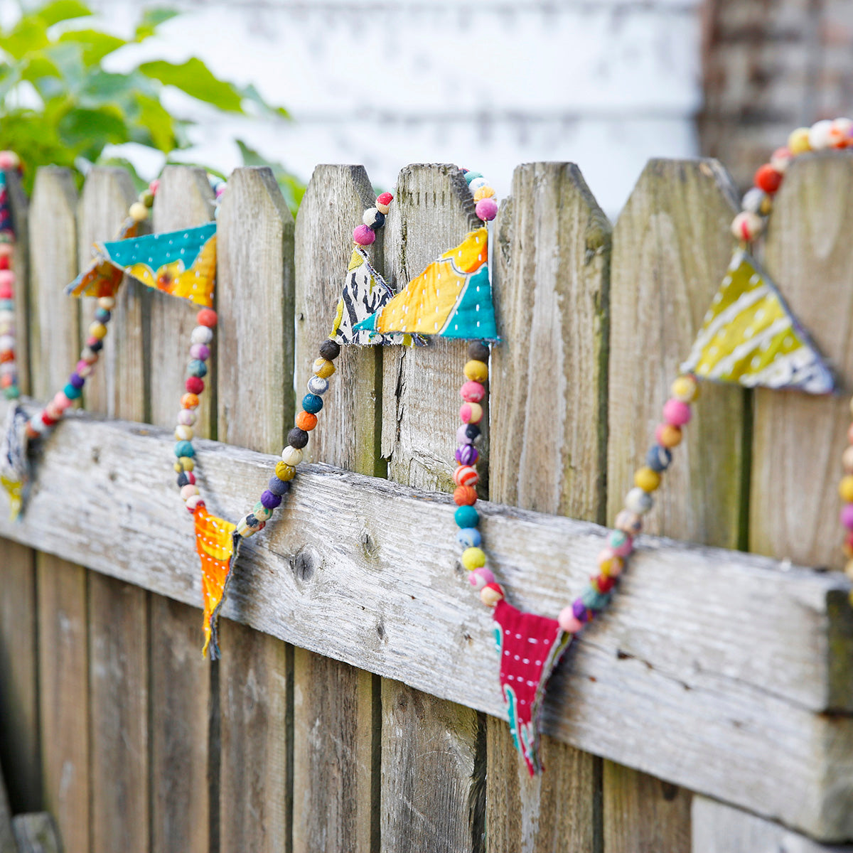 Kantha Bunting Garland hangs on a fence.