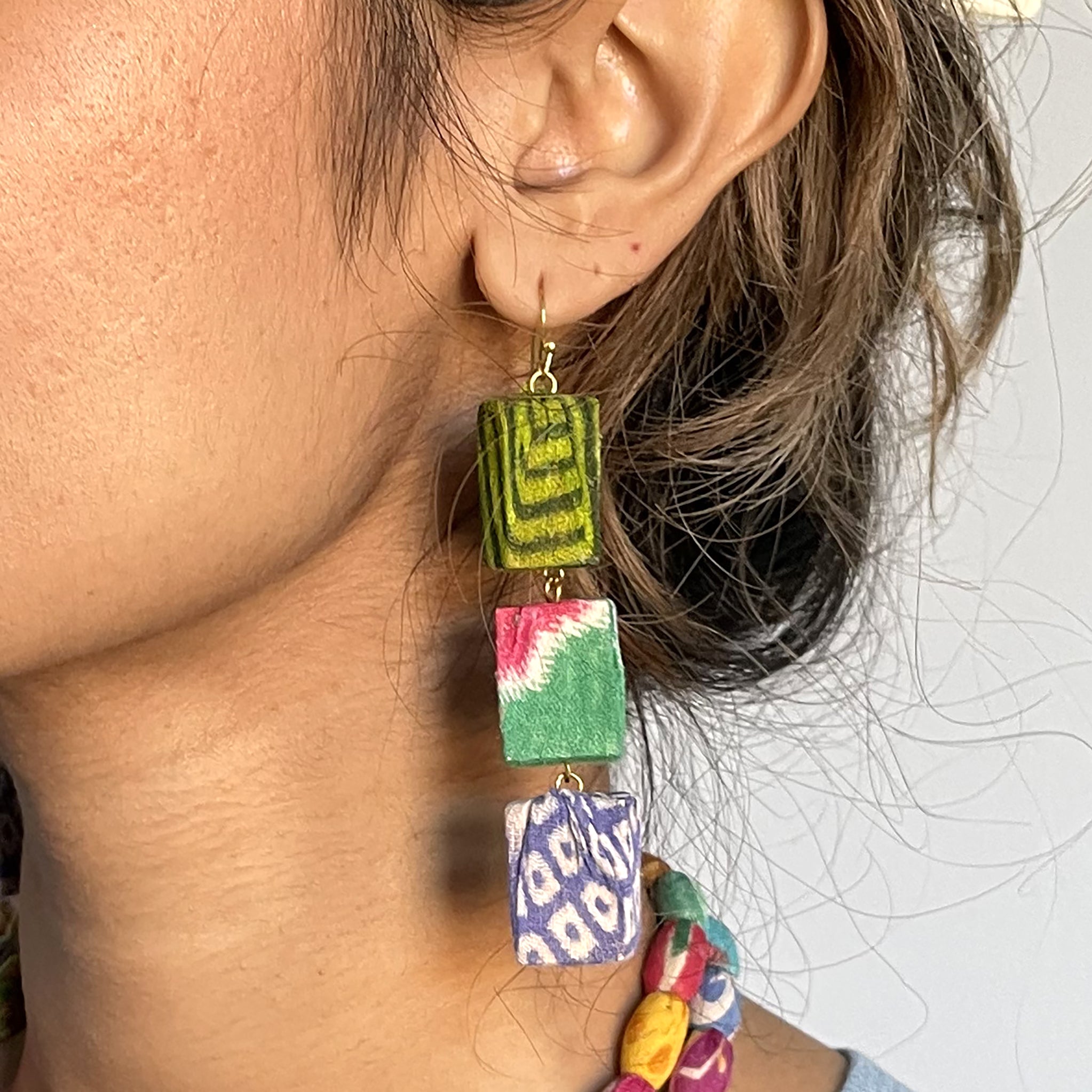 A woman's ear is shown, modeling the Kantha Block Earrings.