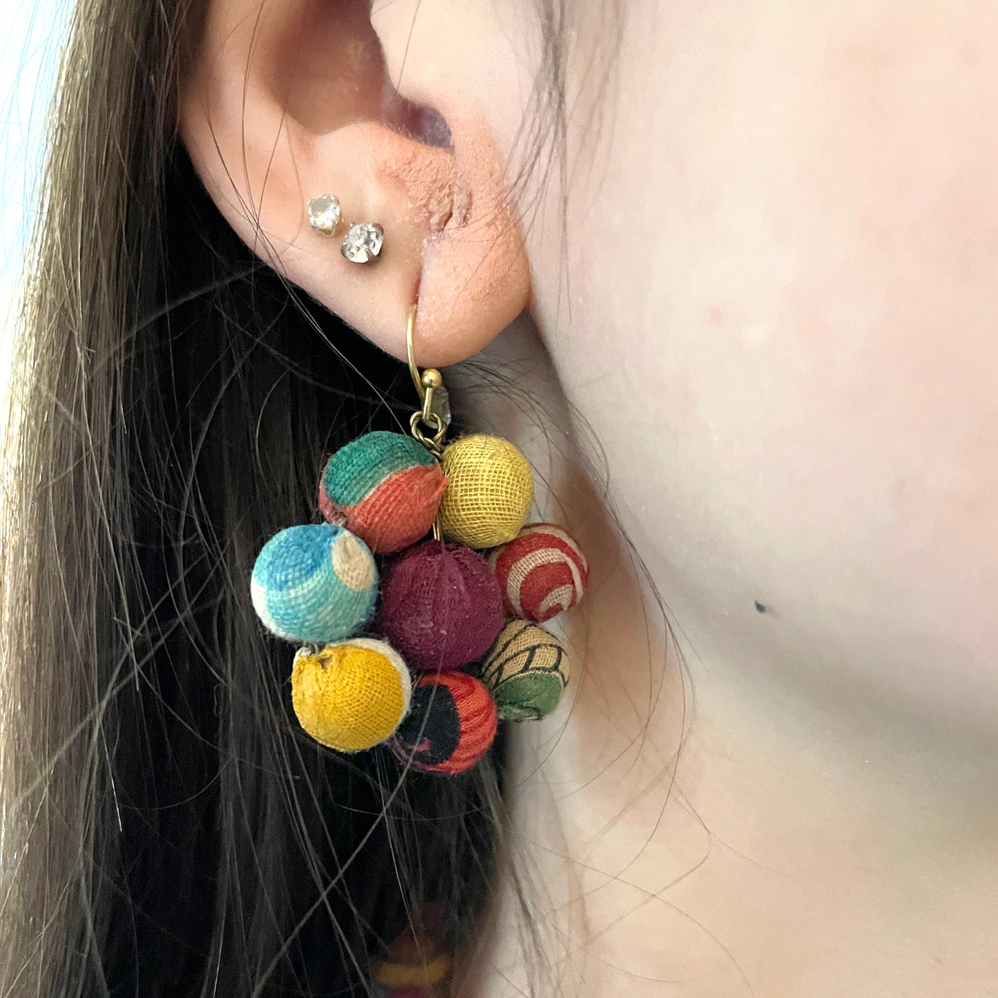 Load image into Gallery viewer, A close-up of an ear is shown with the Kantha Blooming Posy Earrings.
