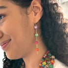 A woman's ear is shown modeling the Kantha Fluid Ellipses Earrings.
